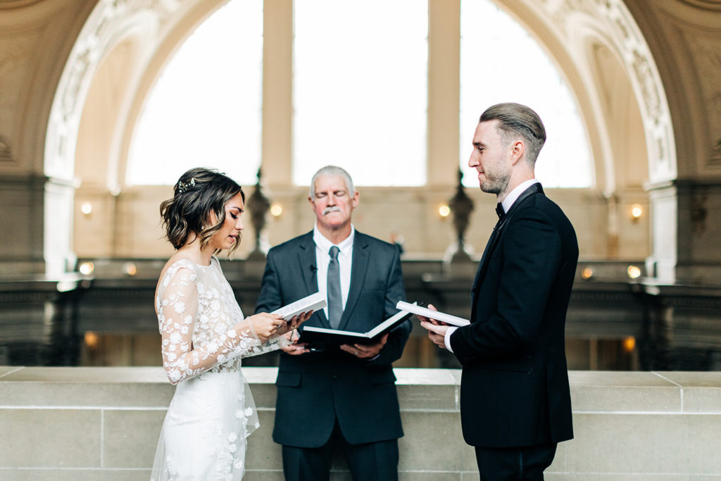 City Hall in San Francisco, CA wedding photography; bride and groom reading the vow