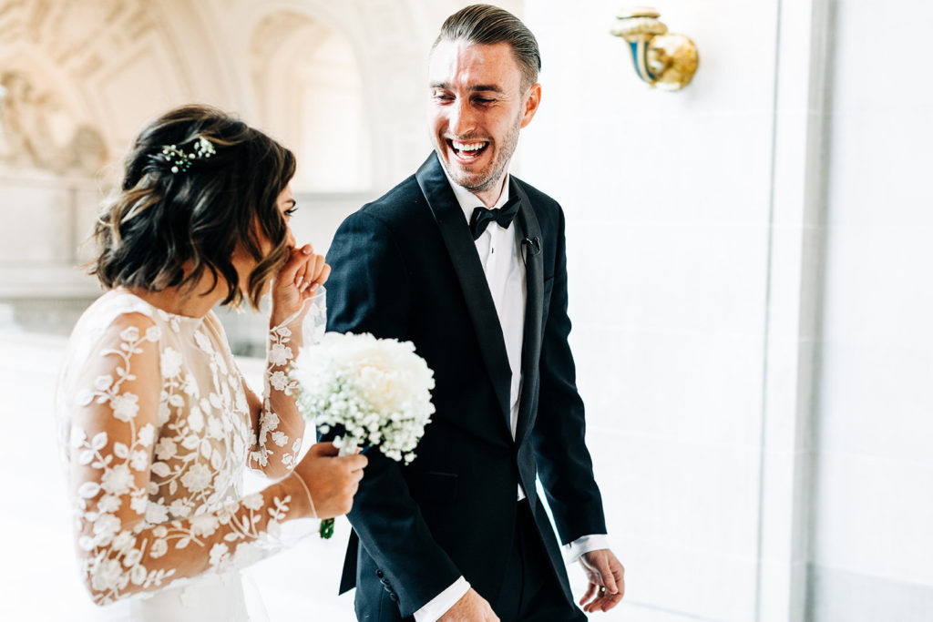 City Hall in San Francisco, CA wedding photography; groom and bride having a laugh together