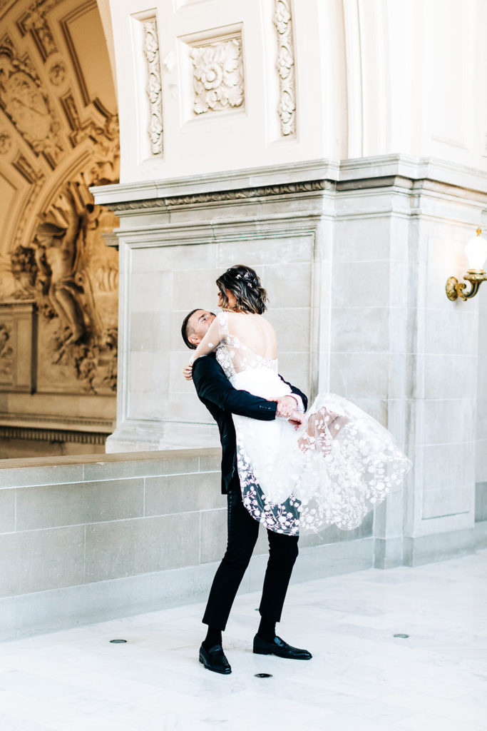 City Hall in San Francisco, CA wedding photography; groom lifting his bride