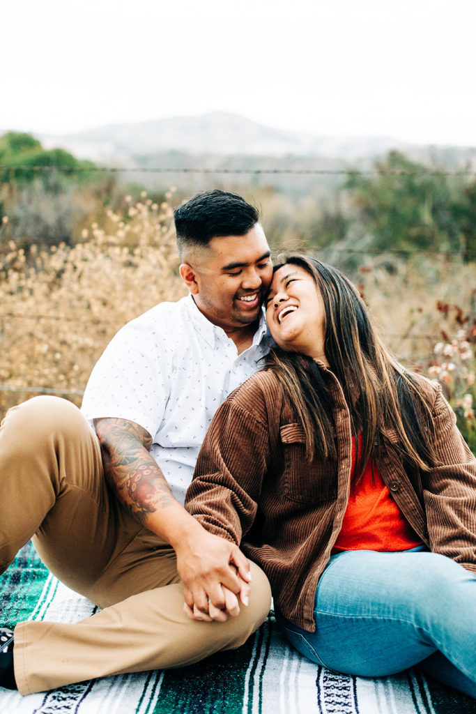 southern california engagement photos; couple sitting together on a blanket