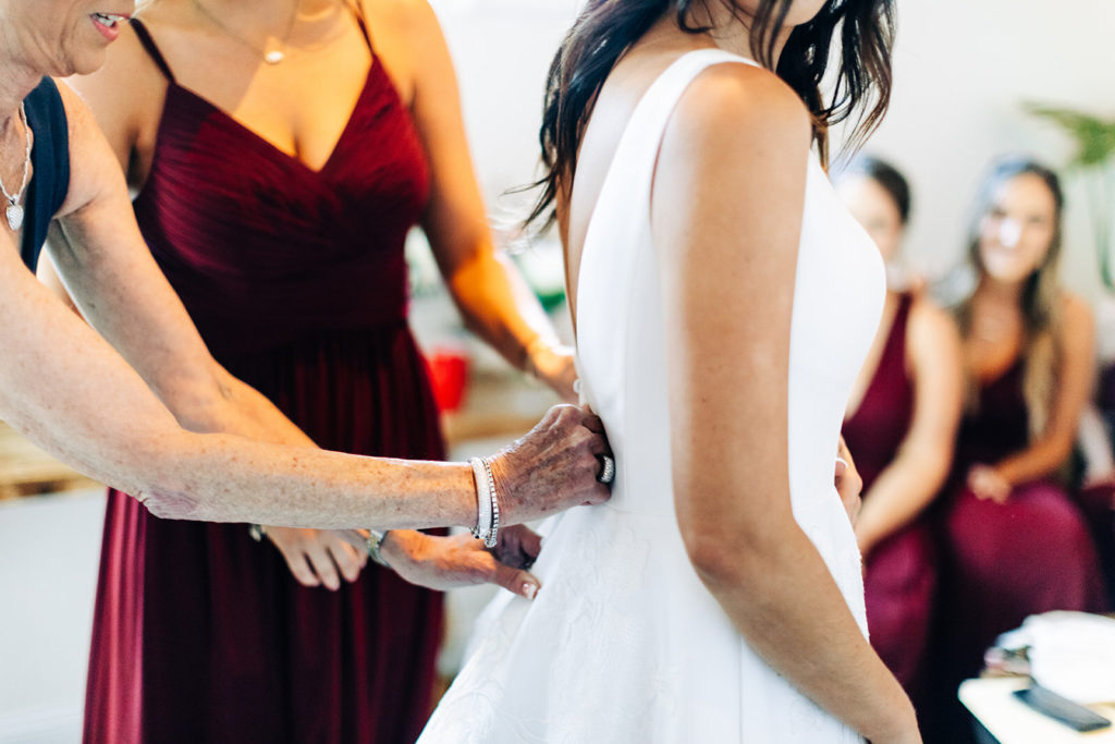Colony house in Anaheim, CA wedding photography; bridesmaids helping bride to get ready