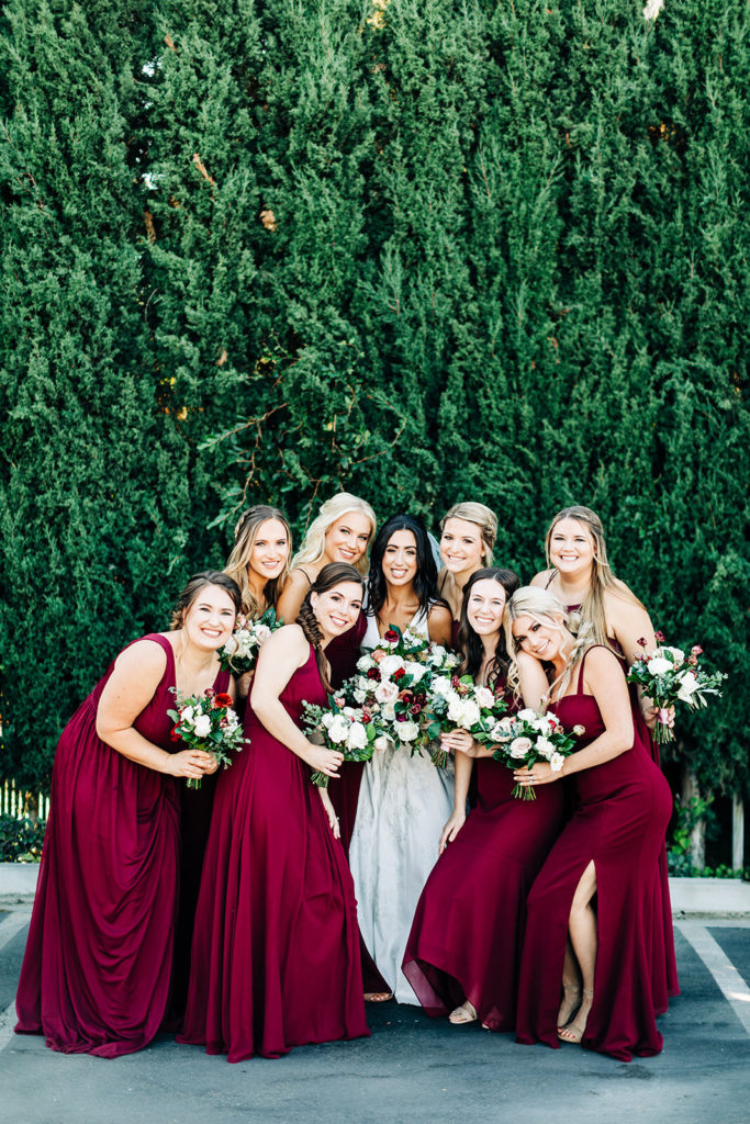 Colony house in Anaheim, CA wedding photography; bride with bridesmaids with a beautiful green background wall