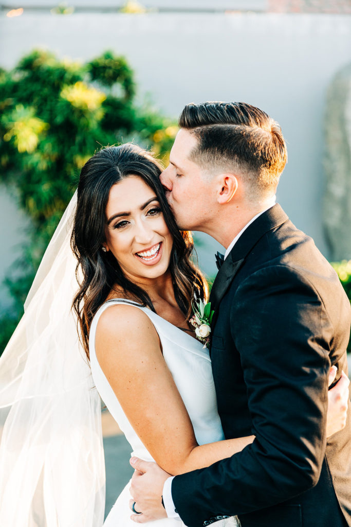 Colony house in Anaheim, CA wedding photography; groom kissing his bride