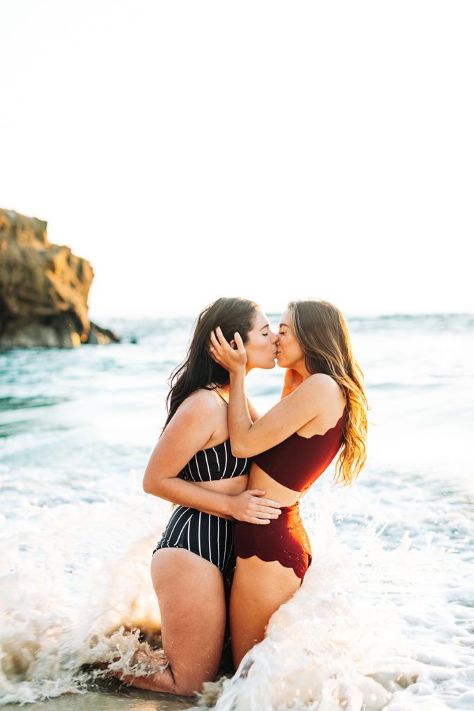 laguna beach engagement photos; lesbian couple kissing in the waves on the beach in laguna beach, ca