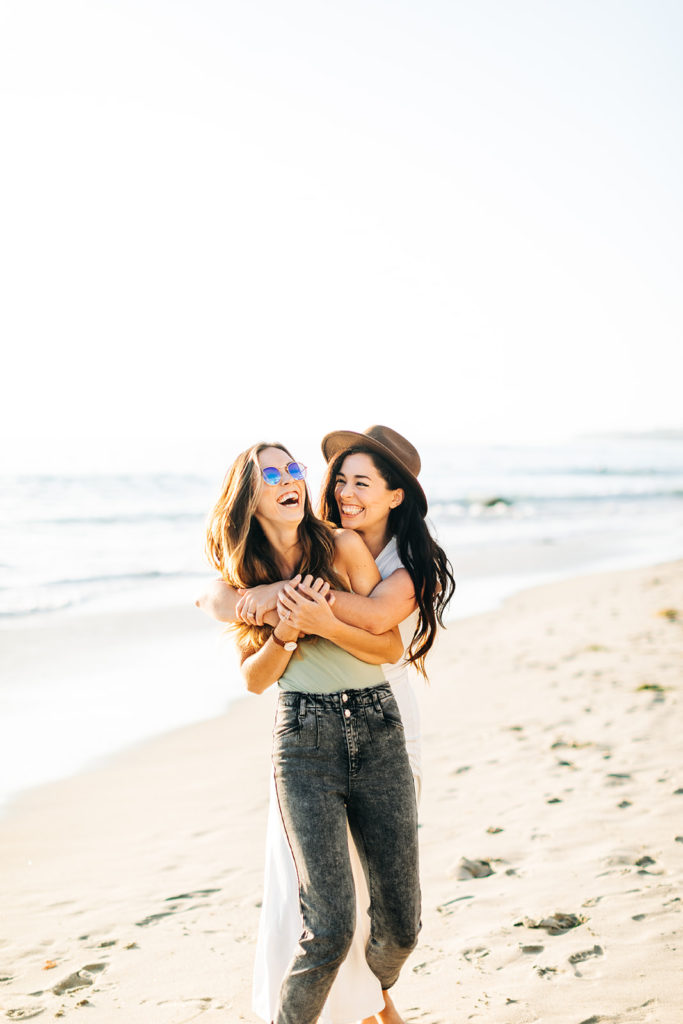 lesbian couple smiling on the beach in laguna beach, ca