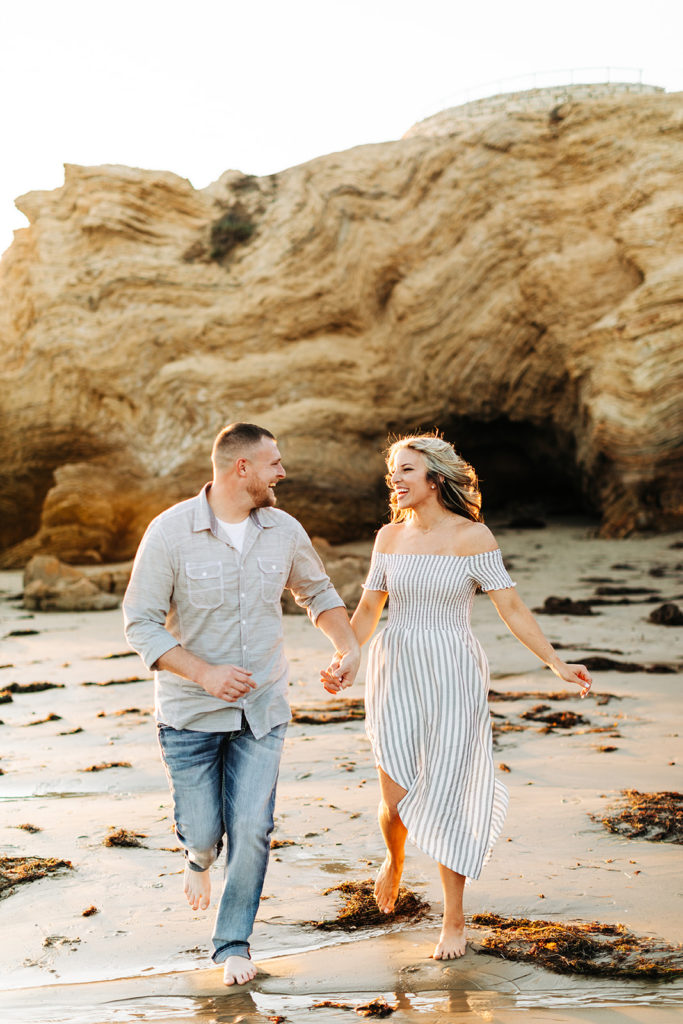 southern california engagement photos locations; couple running on the beach at crystal cove