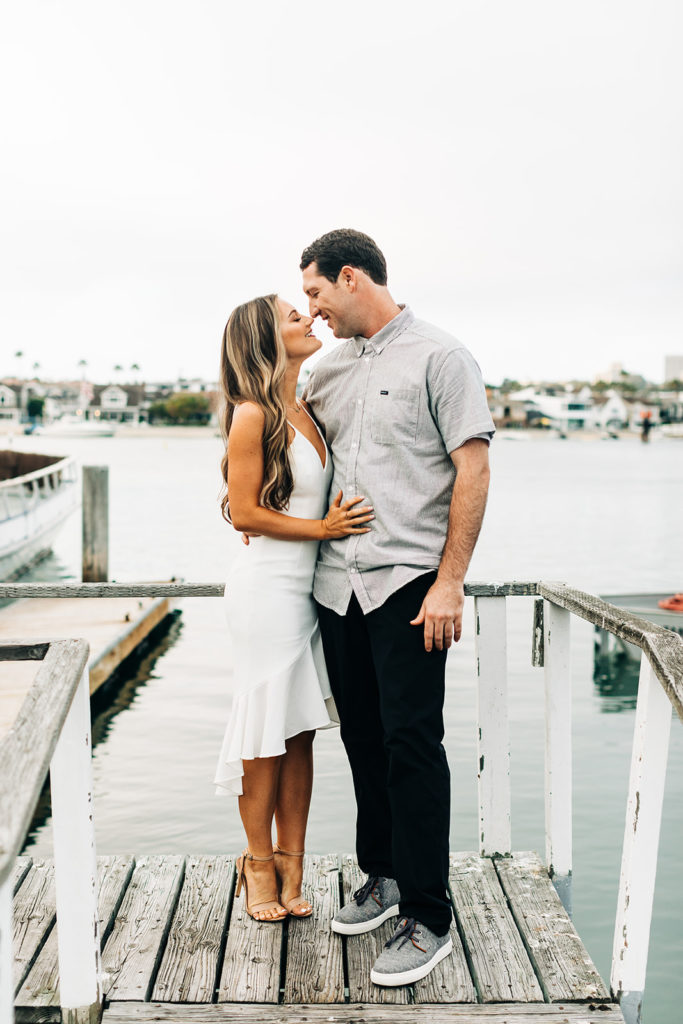 southern california engagement photos; man and woman hugging in the harbor