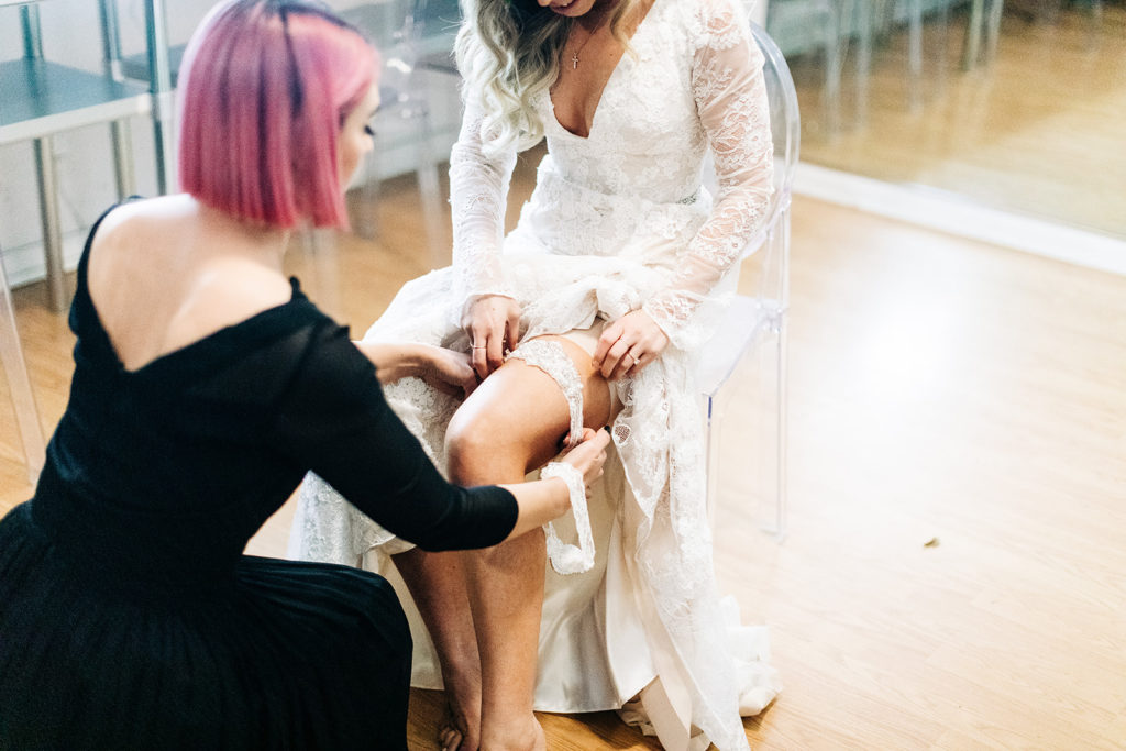 Hartley Botanica wedding photography; bride getting help with her garter