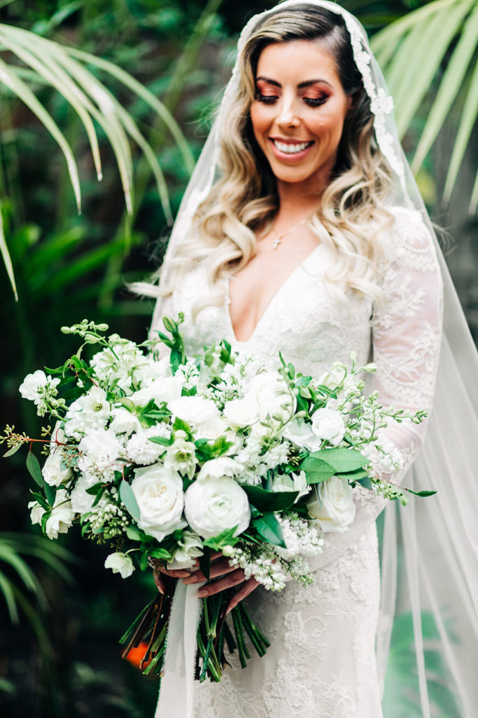 Hartley Botanica wedding photography; bride smiling down at her bouquet