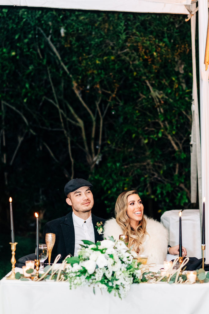 Hartley Botanica wedding photography; bride and groom smiling from their table at outdoor wedding reception