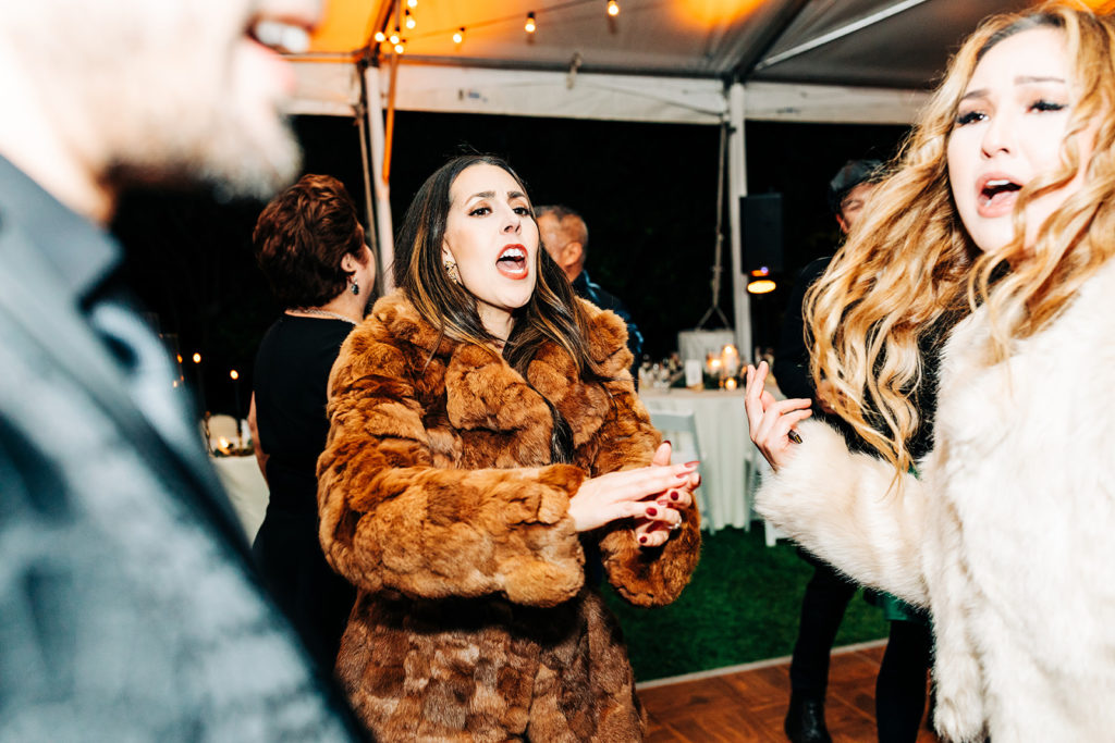 Hartley Botanica wedding photography; guest in brown fur jacket dancing to music
