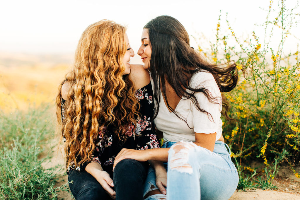 LGBTQ+ wedding photographer; two women smiling at each other while sitting down