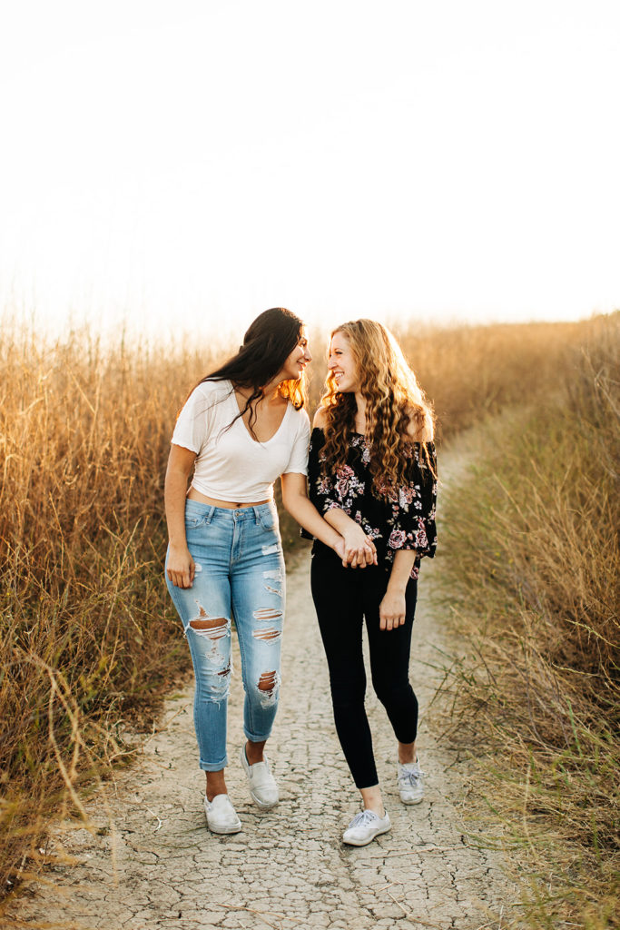 LGBTQ+ wedding photographer; two women walking and holding hands while laughing