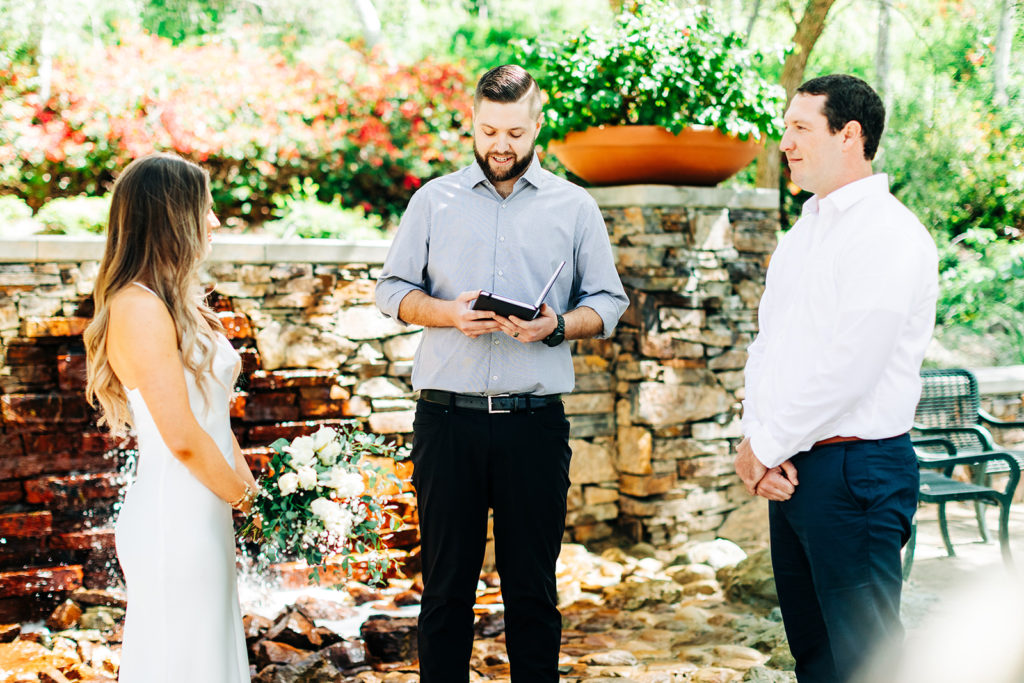 officiant reading at an outdoor wedding while the bride and groom listen; orange county elopement photographer