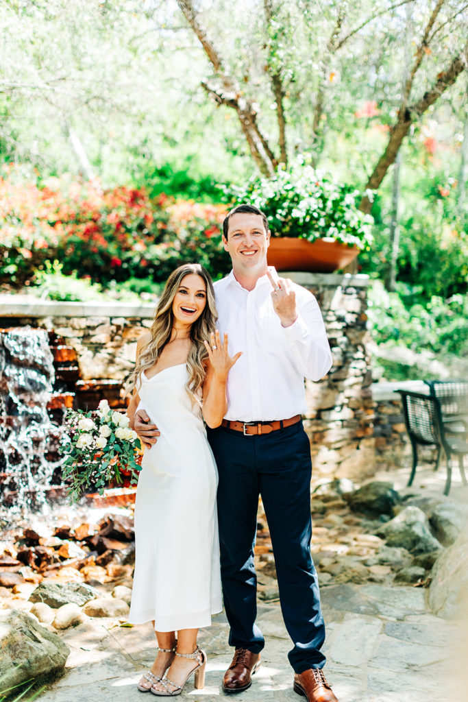 bride and groom showing off their rings on their wedding day while laughing and smiling; orange county elopement photographer