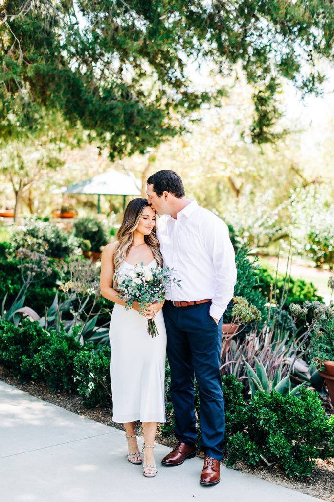 groom kissing his bride's forehead on their wedding day; orange county elopement photographer