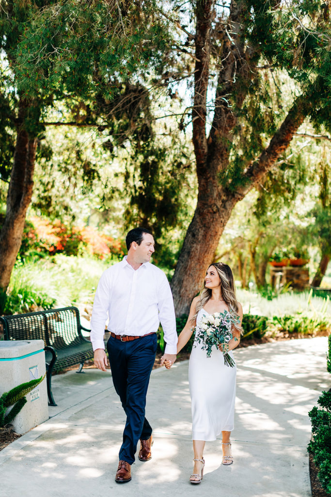 bride and groom walking and holding hands at an outdoor wedding; orange county elopement photographer