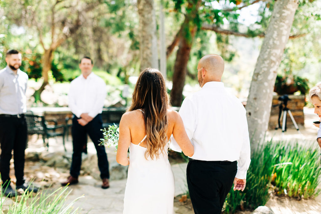 bride and her father walking down the aisle at an outdoor wedding; orange county elopement photographer