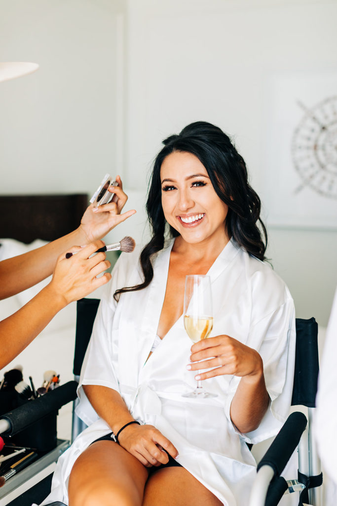 Crystal Cove Micro Wedding in Orange County; bride getting her makeup done on her wedding day
