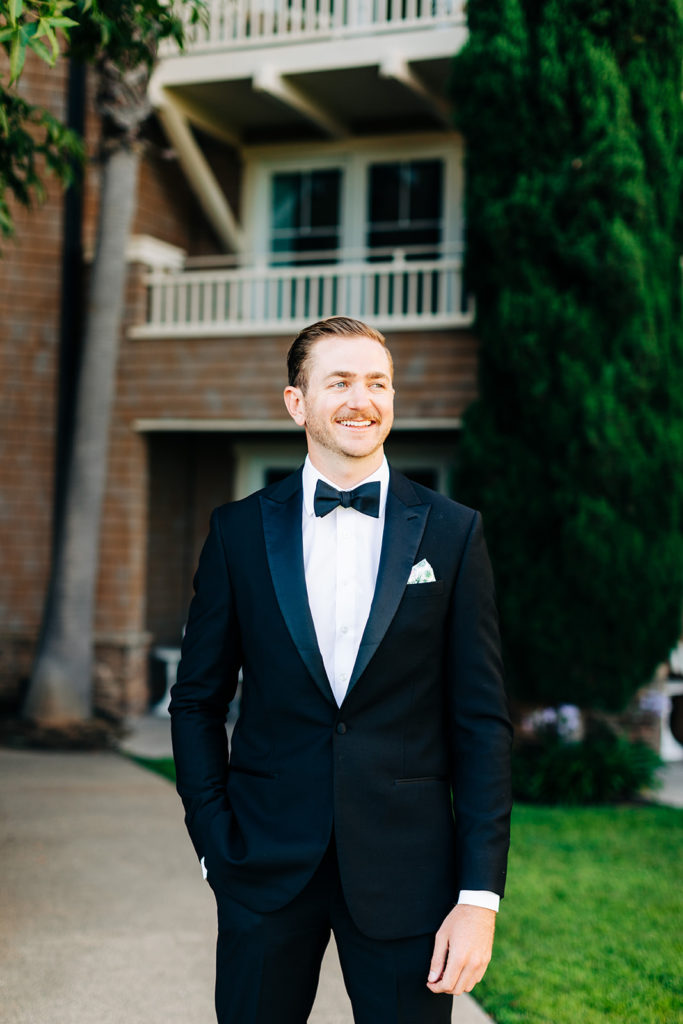Crystal Cove Micro Wedding in Orange County; groom smiling and looking off to the side on his wedding day