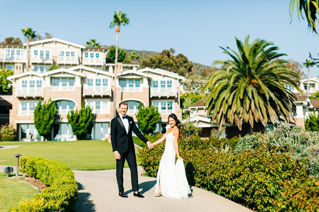 Crystal Cove Micro Wedding in Orange County; bride and groom holding hands and looking at the camera at the montage hotel in laguna beach