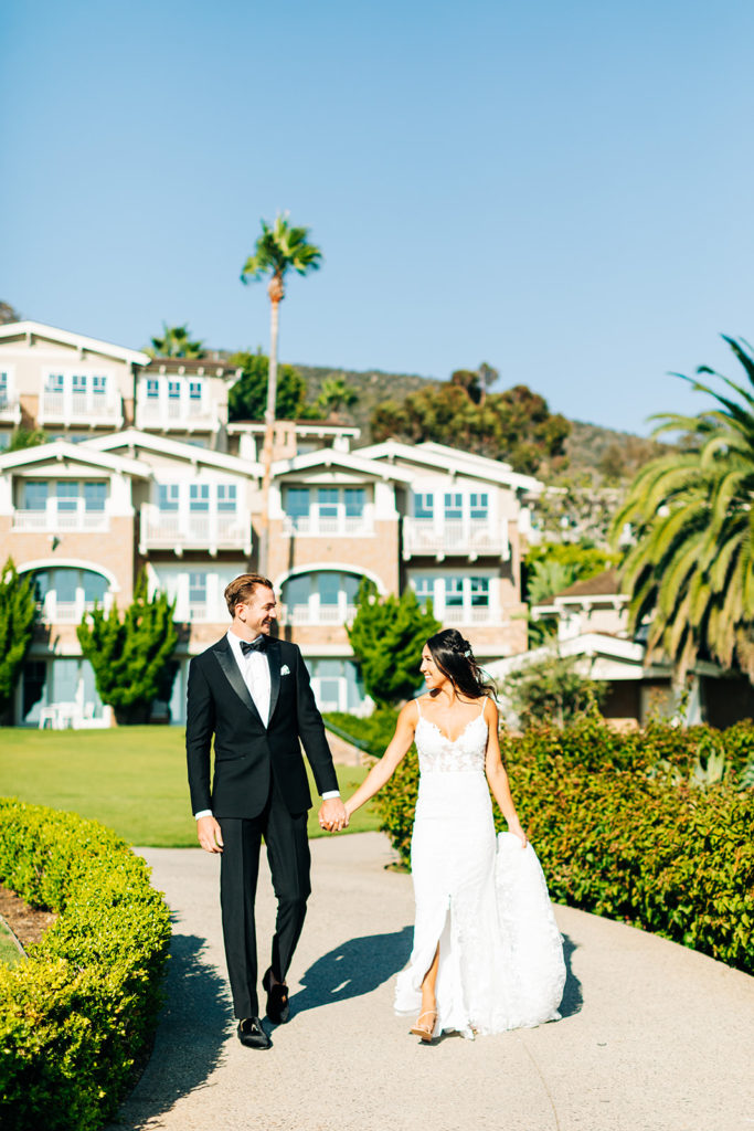 Crystal Cove Micro Wedding in Orange County; bride and groom holding hands and walking toward the camera at the montage hotel in laguna beach