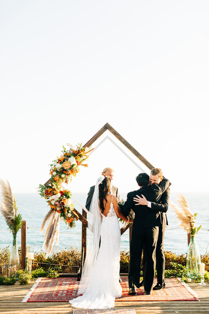 Crystal Cove Micro Wedding in Orange County; bride's father hugs the groom