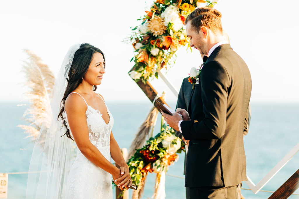 Crystal Cove Micro Wedding in Orange County; groom reading his personal vows to the bride at their wedding