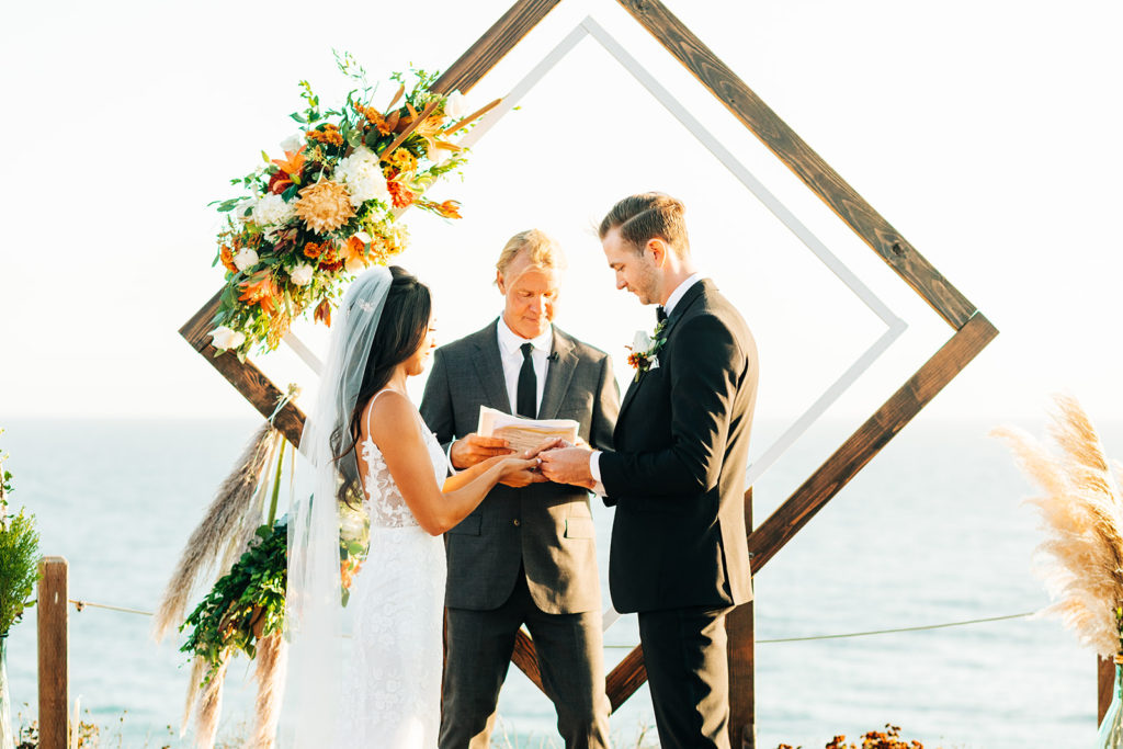 Crystal Cove Micro Wedding in Orange County; bride and groom exchanging rings at their wedding