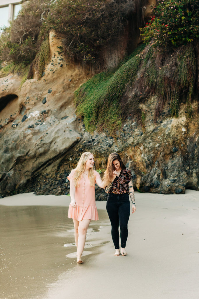 LGBTQ+ wedding photographer in san diego; a lesbian couple walking hand in hand at the beach