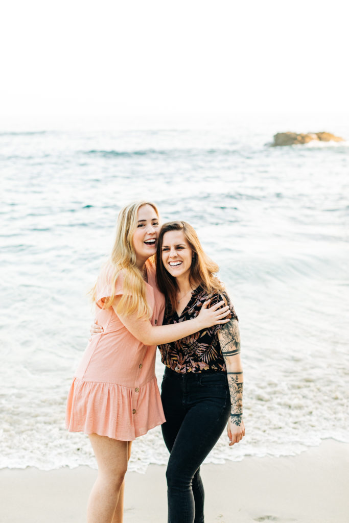 LGBTQ+ wedding photographer in san diego; a lesbian couple smiling and holding each other at the beach