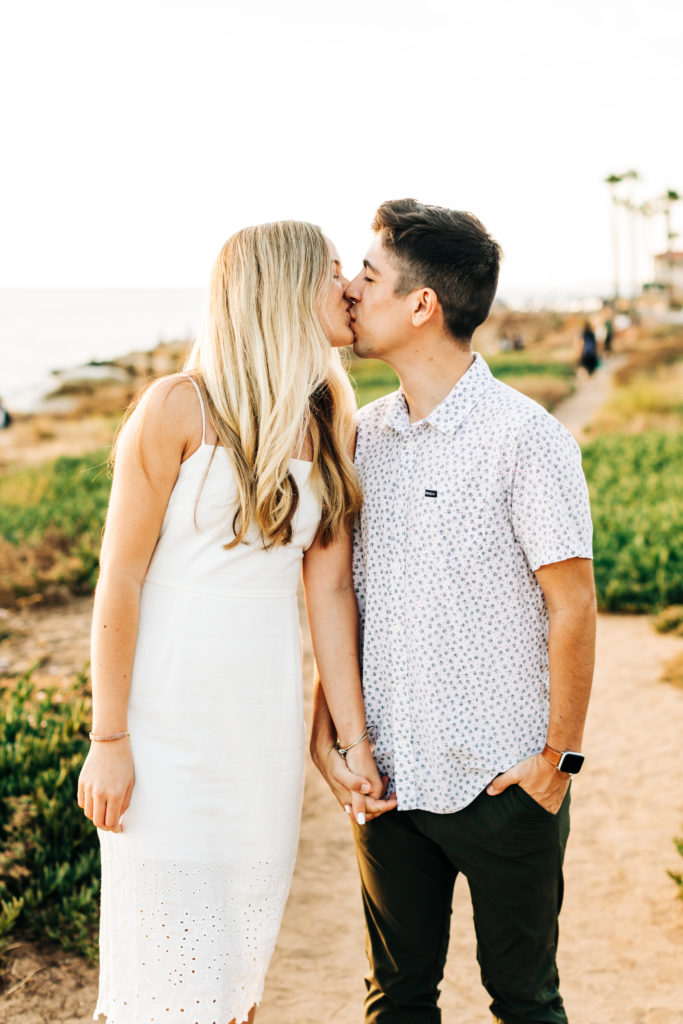 san diego engagement photos at sunset cliffs; san diego wedding photographer; a man and woman kissing