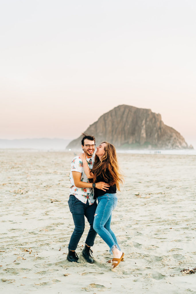 Sunset Engagement Photos at Morro Bay, morro bay wedding photographer; a man and woman hugging on the beach in Morro Bay, California