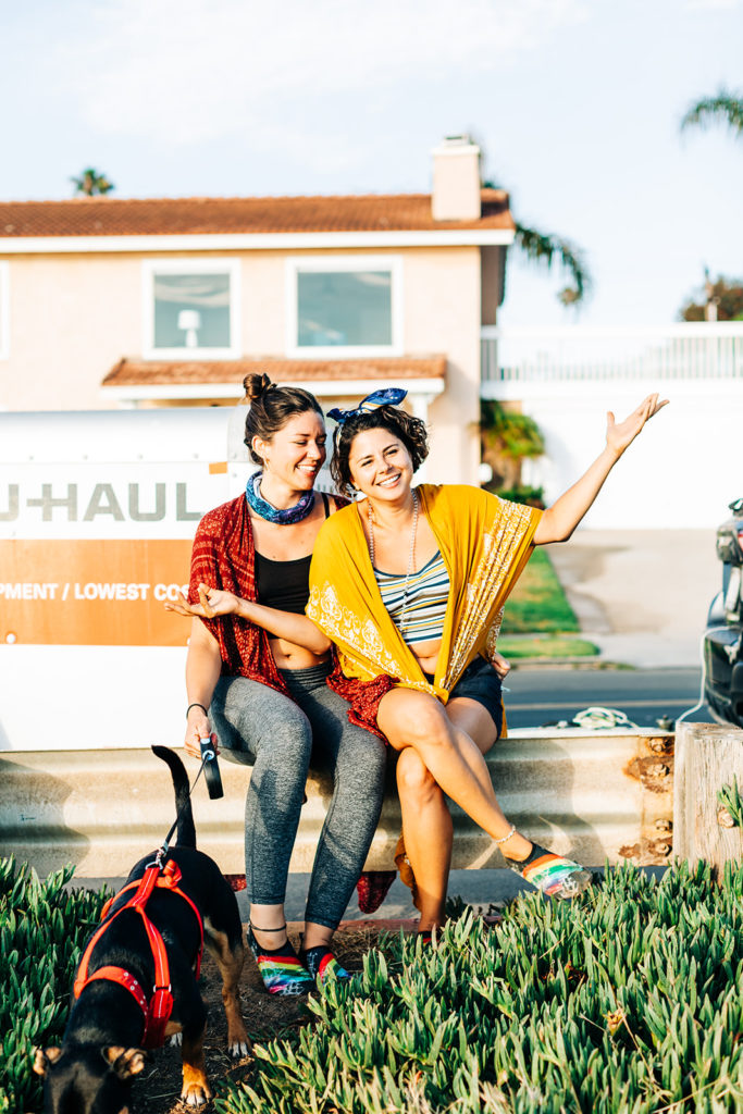 san diego wedding photographer; two women sitting in front of a uhaul smiling and laughing