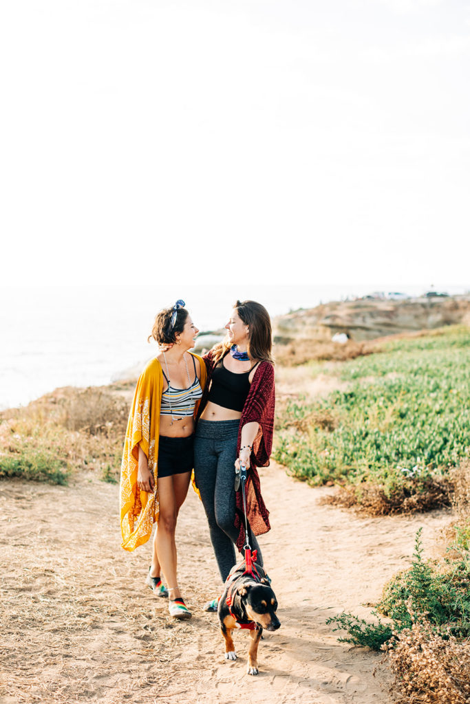 san diego wedding photographer; sunset cliffs engagement photos; a female couple walking and holding hands at sunset cliffs in san diego, california