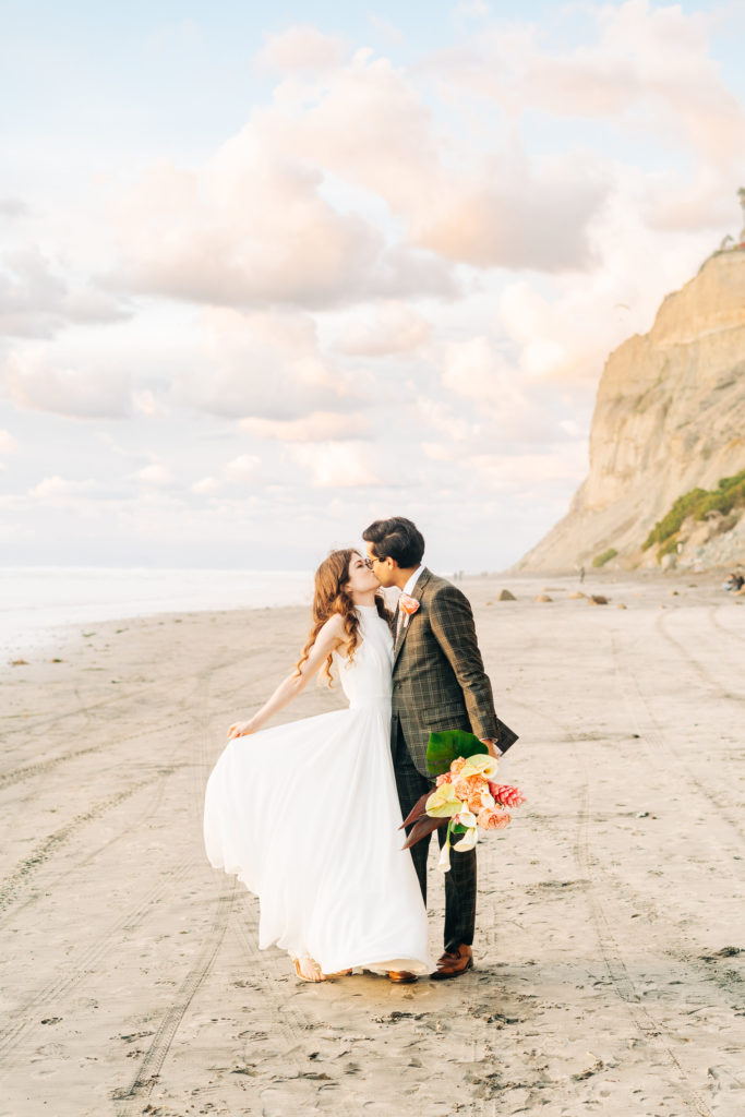 micro wedding in san diego; a man and woman couple kiss on the beach in san diego, ca