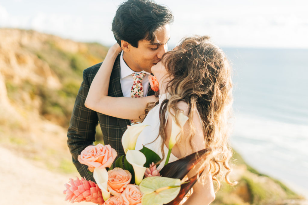 micro wedding in san diego; a bride and groom kiss after their micro-wedding at torrey pines gliderport in san diego