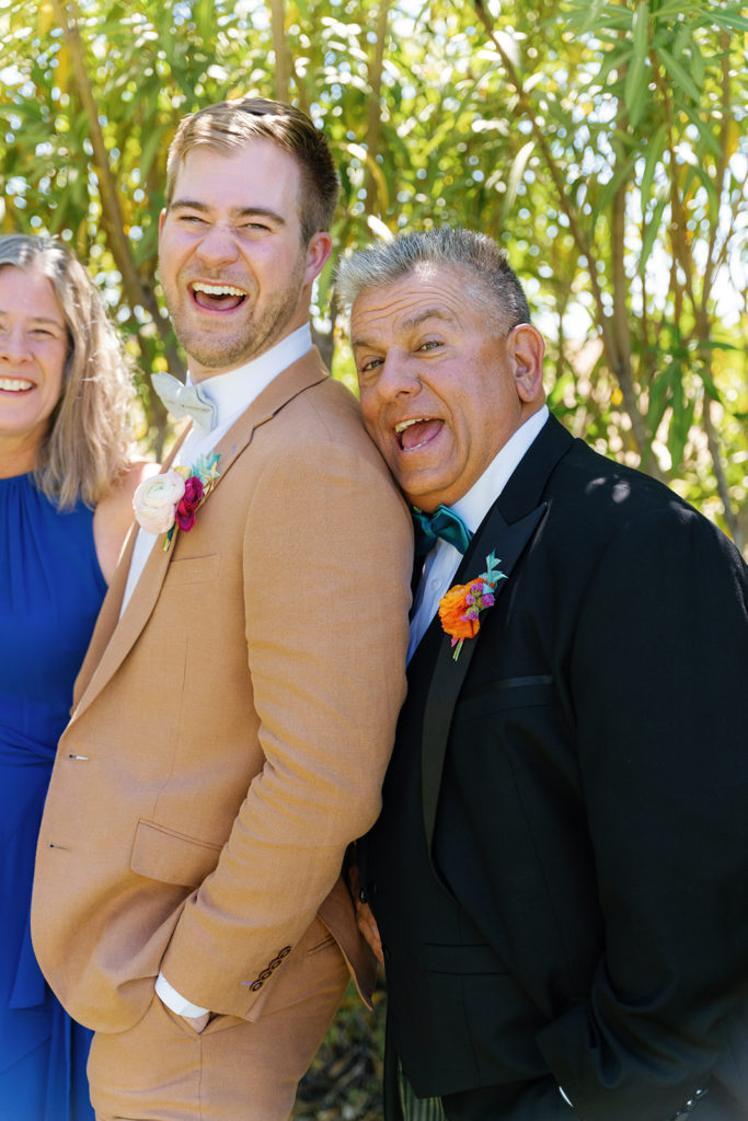 father of a groom and the other groom smiling; gay wedding in temecula at mount palomar winery