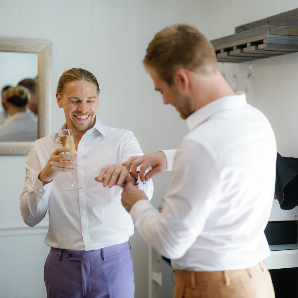 a groom helps his groom put his watch on; gay wedding in temecula at mount palomar winery