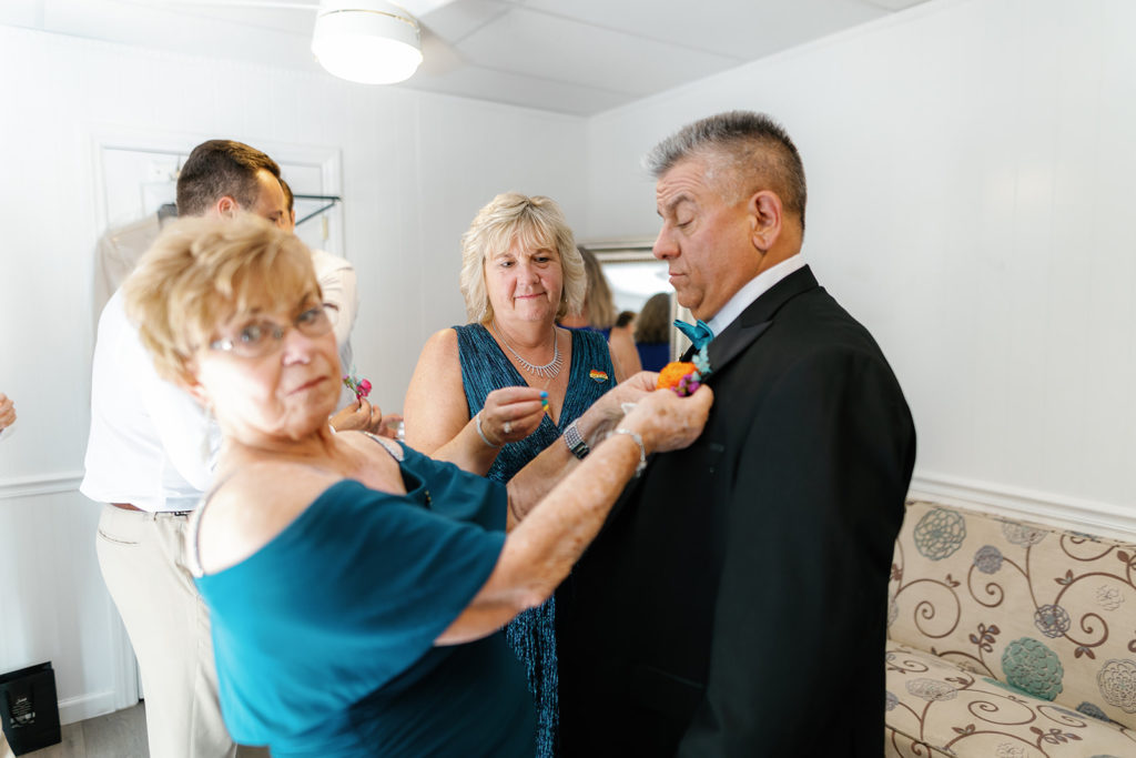 grandma helping put on grooms dad's boutonniere; gay wedding in temecula at mount palomar winery