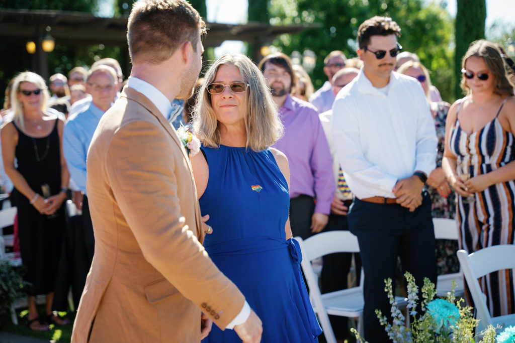 Groom and his mother as he walks down the aisle; gay wedding in temecula at mount palomar winery