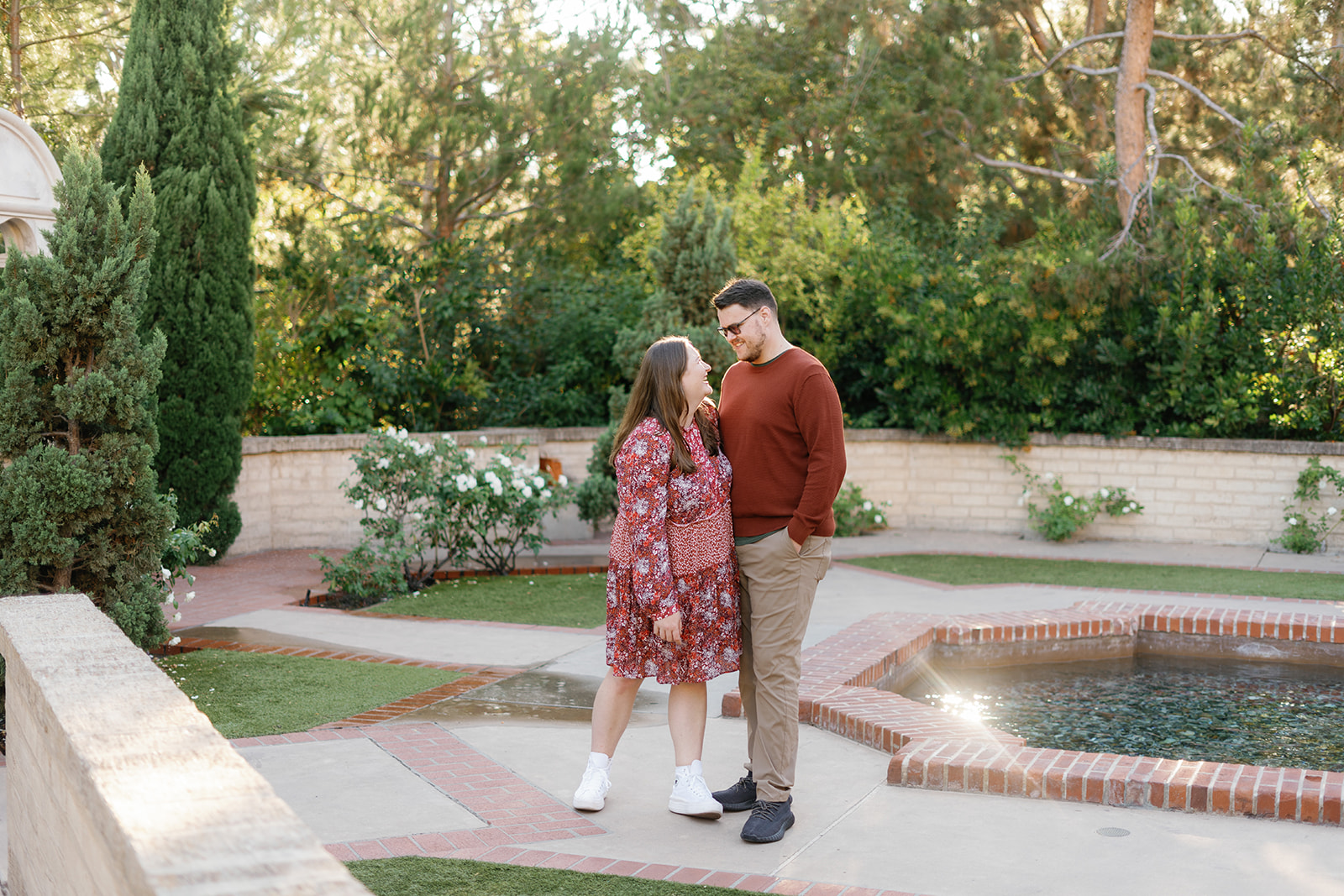 balboa park engagement photos; a couple taking their engagement photos in balboa park, they are smiling at each other.