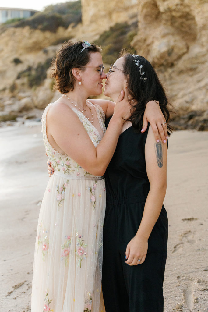non-binary wedding photography; a non-binary couple almost kisses on their wedding day