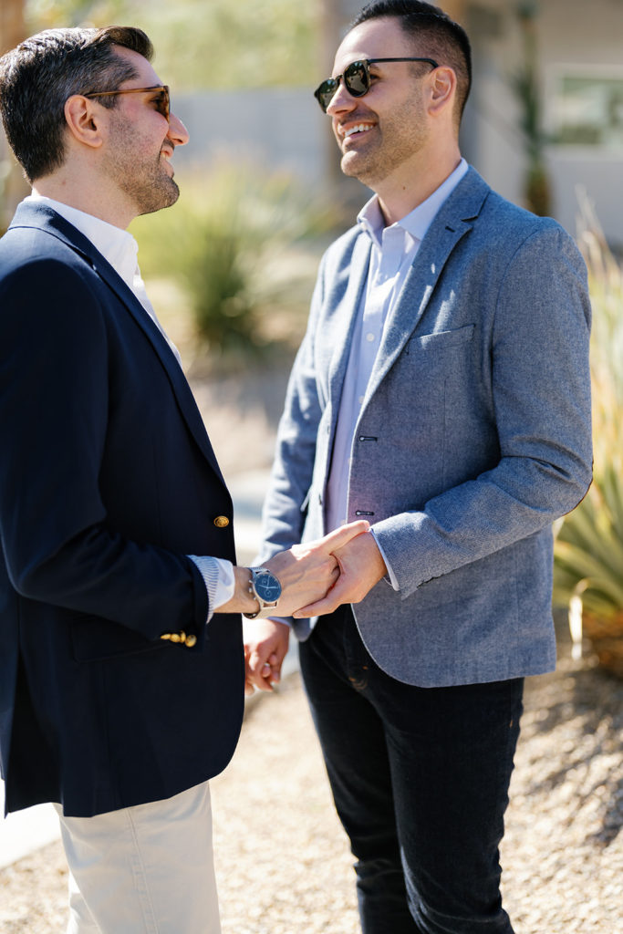 palm springs engagement photos; a gay couple holding hands facing each other