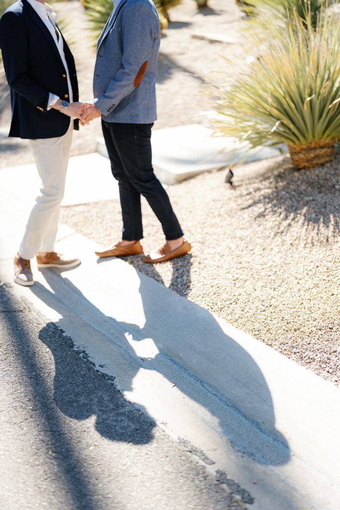 palm springs engagement photos; the shadows of a gay couple facing each other holding hands