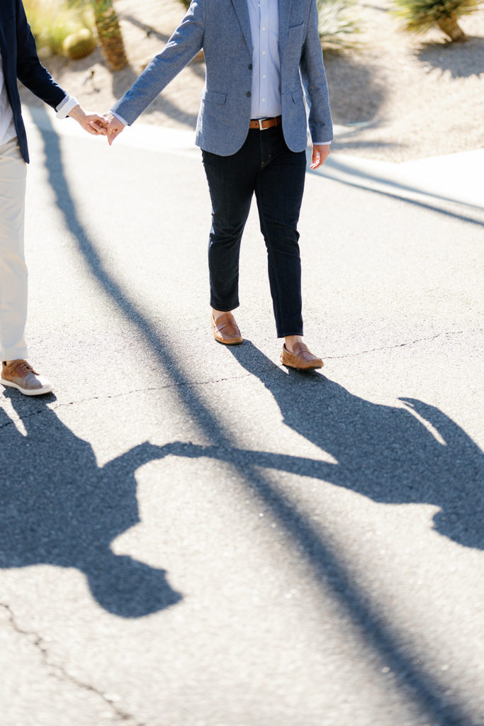 palm springs engagement photos; the shadows of a gay couple holding hands and walking