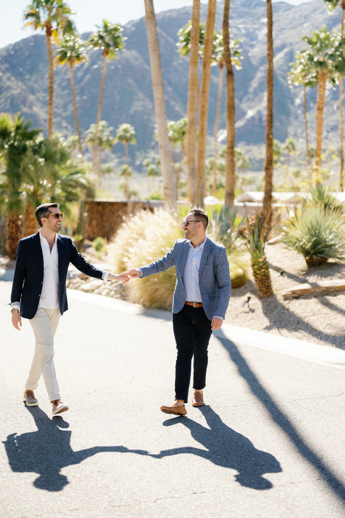 palm springs engagement photos; a gay couple holding hands with palm trees in the background
