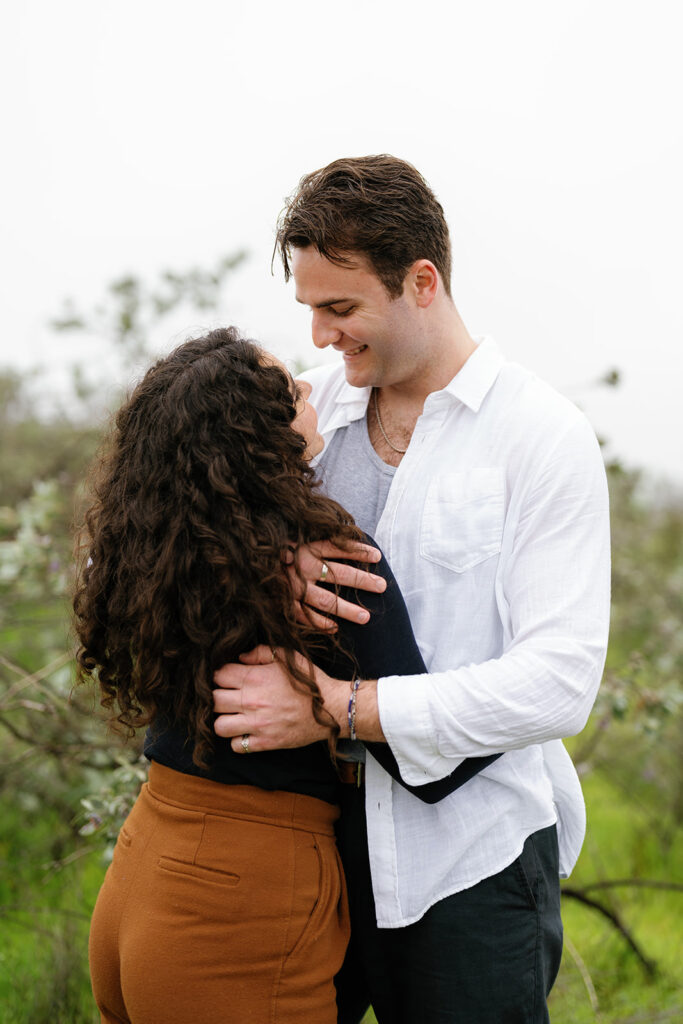 romantic san diego engagement photos; romantic location for engagement photos in san diego; a couple hugging and looking at each other lovingly