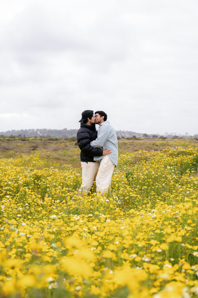wildflowers superbloom in san diego; a gay couple kisses in a field of wildflowers